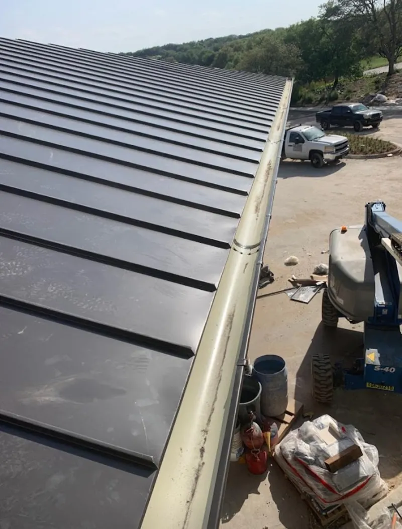 Standing seam panel and gutter detail on a metal roofing jobsite in Smithtown